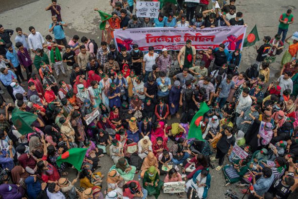 Protesters hold a banner while chanting slogans during a