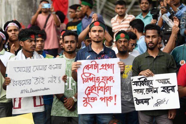 Protesters hold placards expressing their opinions during a