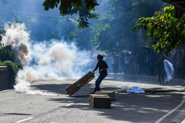 Bangladesh police personnel fire tear shells as students
