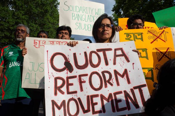 A demonstrator holding a sign with Quota Reform Movement