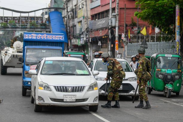 Bangladeshi soldier speaks to a driver in the Bijoy Sarani