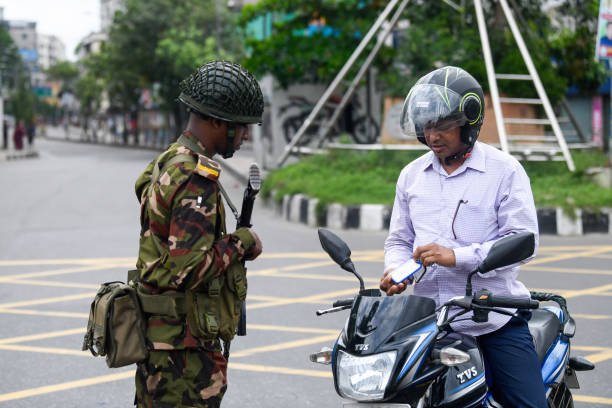 A Bangladeshi soldier seen speaking to a Motorcyclist in the