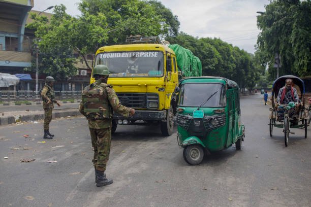 Members of the Bangladesh Army speaks to a driver in the