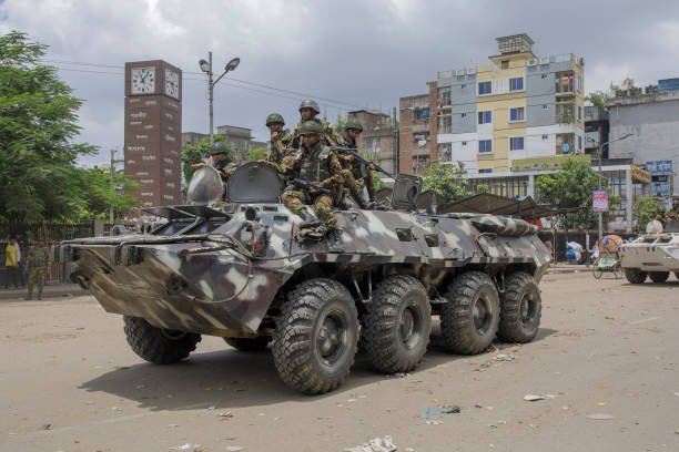Members of the Bangladesh Army gesture patrol in an armored