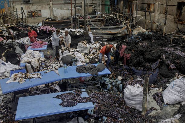 Worker's sort burnt clothes after unidentified protesters