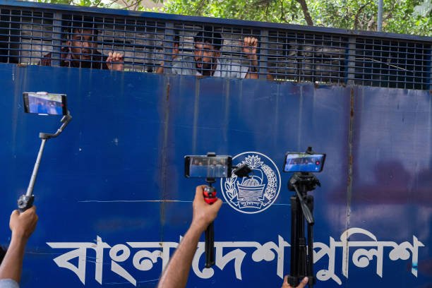 Protesters are detained in a police van during the