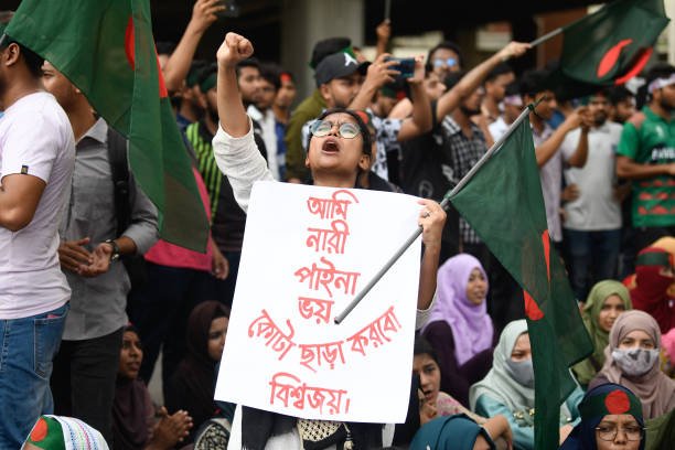 A protestor chants slogans while holding a placard