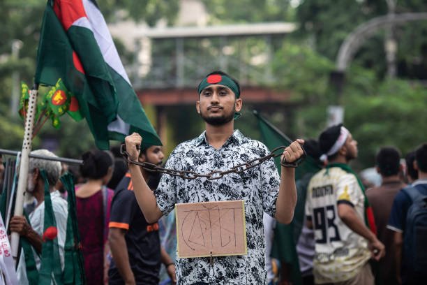A protester holds a chain and a placard during the