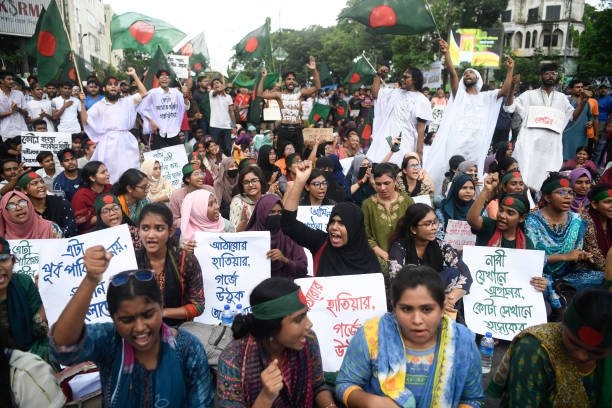 Protesters chant slogans and hold placards expressing their