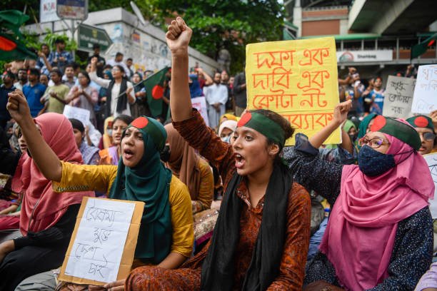 Protesters chant slogans and hold placards expressing their