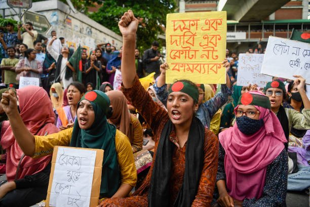 Protesters chant slogans and hold placards expressing their